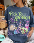 A woman wearing a blue t-shirt with a Halloween-themed graphic and text, holding a drink in a glass.