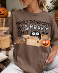 A person wearing a t-shirt with a humorous Halloween-themed graphic, including a cat, pumpkin, and text that says "Easily distracted by Spooky Shit".
