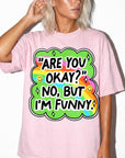 A woman wearing a pink t-shirt with a colorful graphic and text on it.