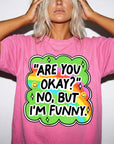 A woman wearing a pink t-shirt with a colorful graphic and text on it.