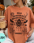 A woman wearing an orange t-shirt with a Ouija board design and text printed on it, holding a drink in a glass.