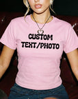 A woman wearing a pink t-shirt with the text "CUSTOM TEXT/PHOTO" printed on it.