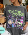 A woman wearing a t-shirt with a Halloween-themed graphic and holding a drink, with a pumpkin and other Halloween decorations visible in the background.