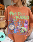 A woman wearing a t-shirt with a Halloween-themed graphic and holding a drink, with a pumpkin and other Halloween decorations visible in the background.