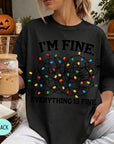 A woman wearing a black t-shirt with a graphic design of colorful lights and the text "I'm Fine. Everything is Fine." She is holding a drink in a glass with a straw.