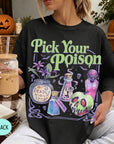 A woman wearing a black t-shirt with a Halloween-themed graphic design, holding a drink and surrounded by Halloween decorations.