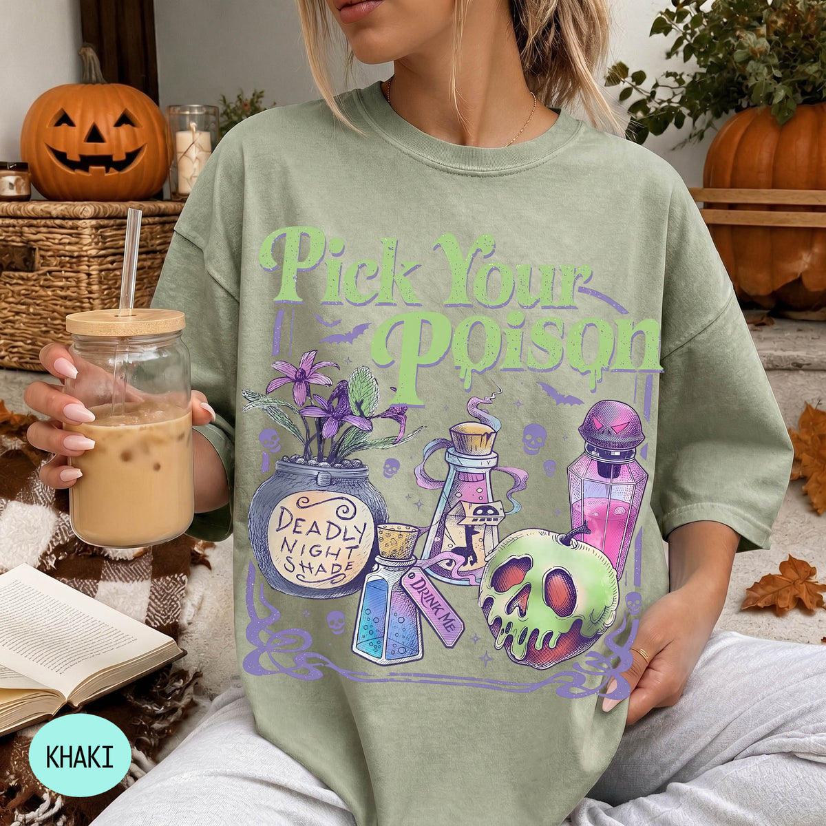 A woman wearing a green t-shirt with a Halloween-themed graphic and text, holding a drink in a glass.