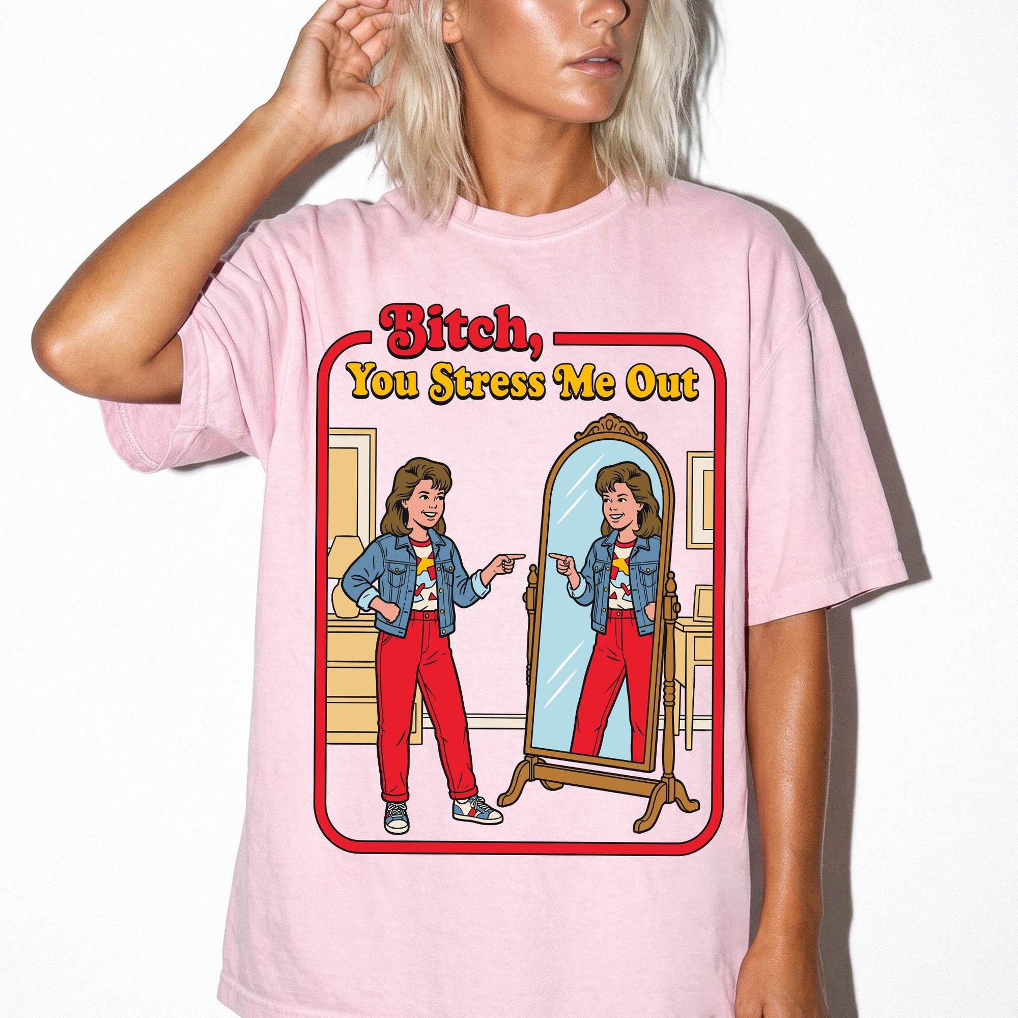 A woman wearing a pink t-shirt with a graphic design depicting a woman in a mirror, with text above the image that says "Bitch, You Stress Me Out".
