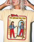 a woman wearing a yellow t-shirt with a graphic design depicting a woman looking into a mirror and pointing at herself.