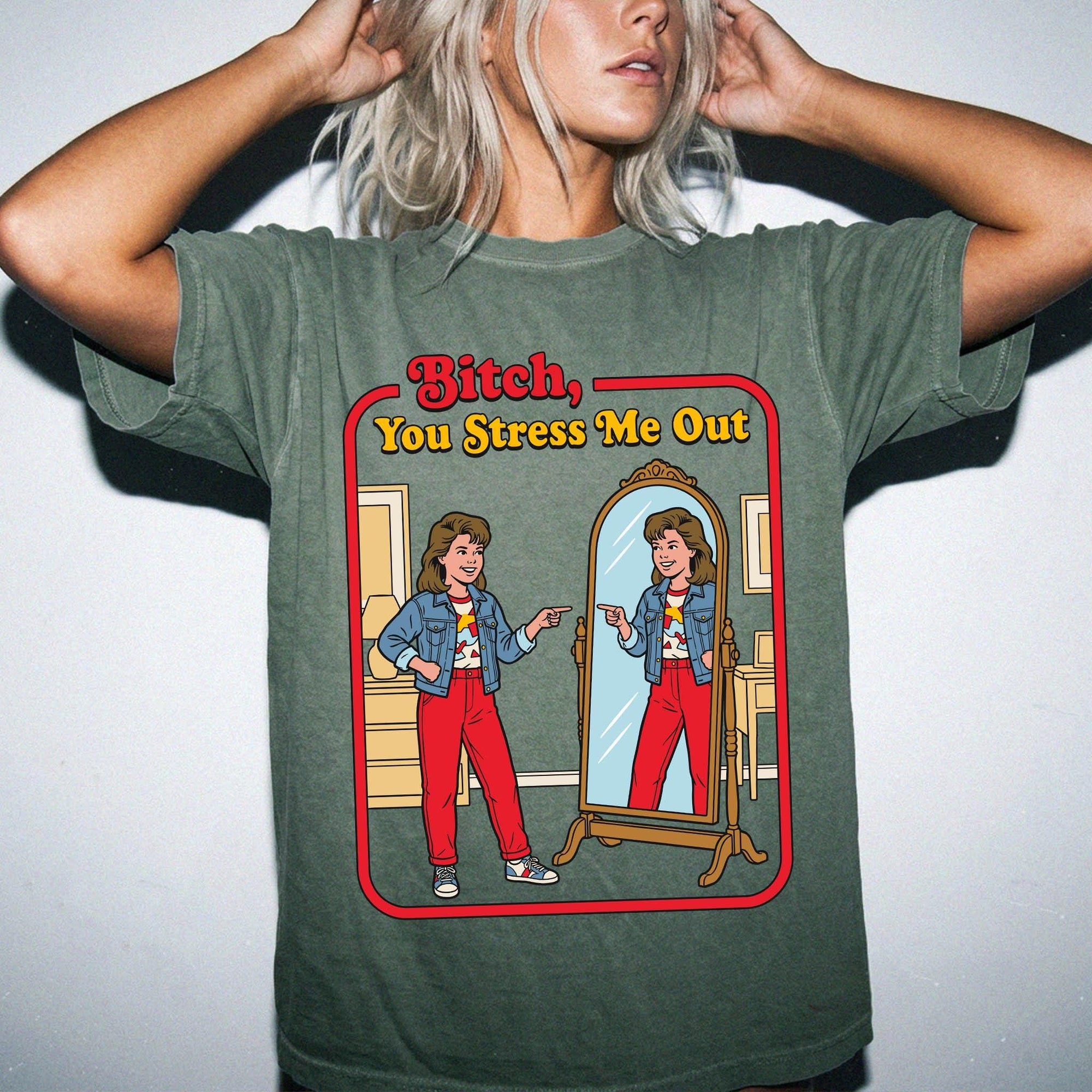 A woman wearing a green t-shirt with a graphic design depicting a woman looking into a mirror and the text &amp;quot;Bitch, You Stress Me Out&amp;quot; above the image.