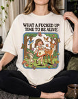 A person wearing a white t-shirt with a graphic design depicting a girl surrounded by various animals, including a deer, butterflies, and mushrooms, along with the text "What a FUCKED UP TIME TO BE ALIVE".