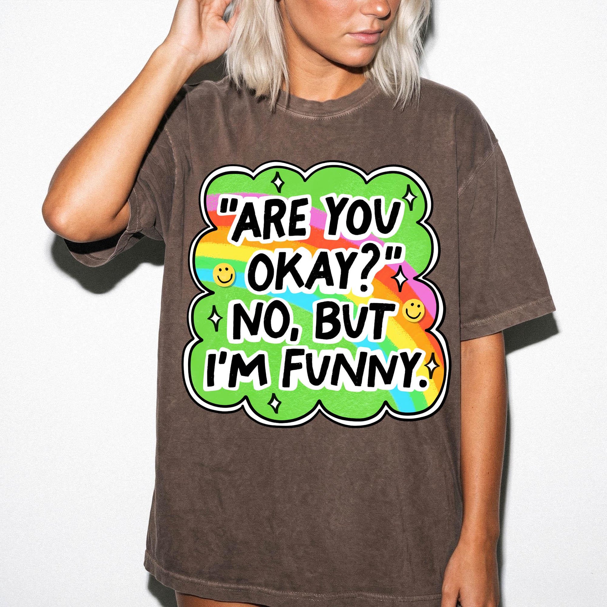 A woman wearing a brown t-shirt with a colorful graphic design and text.