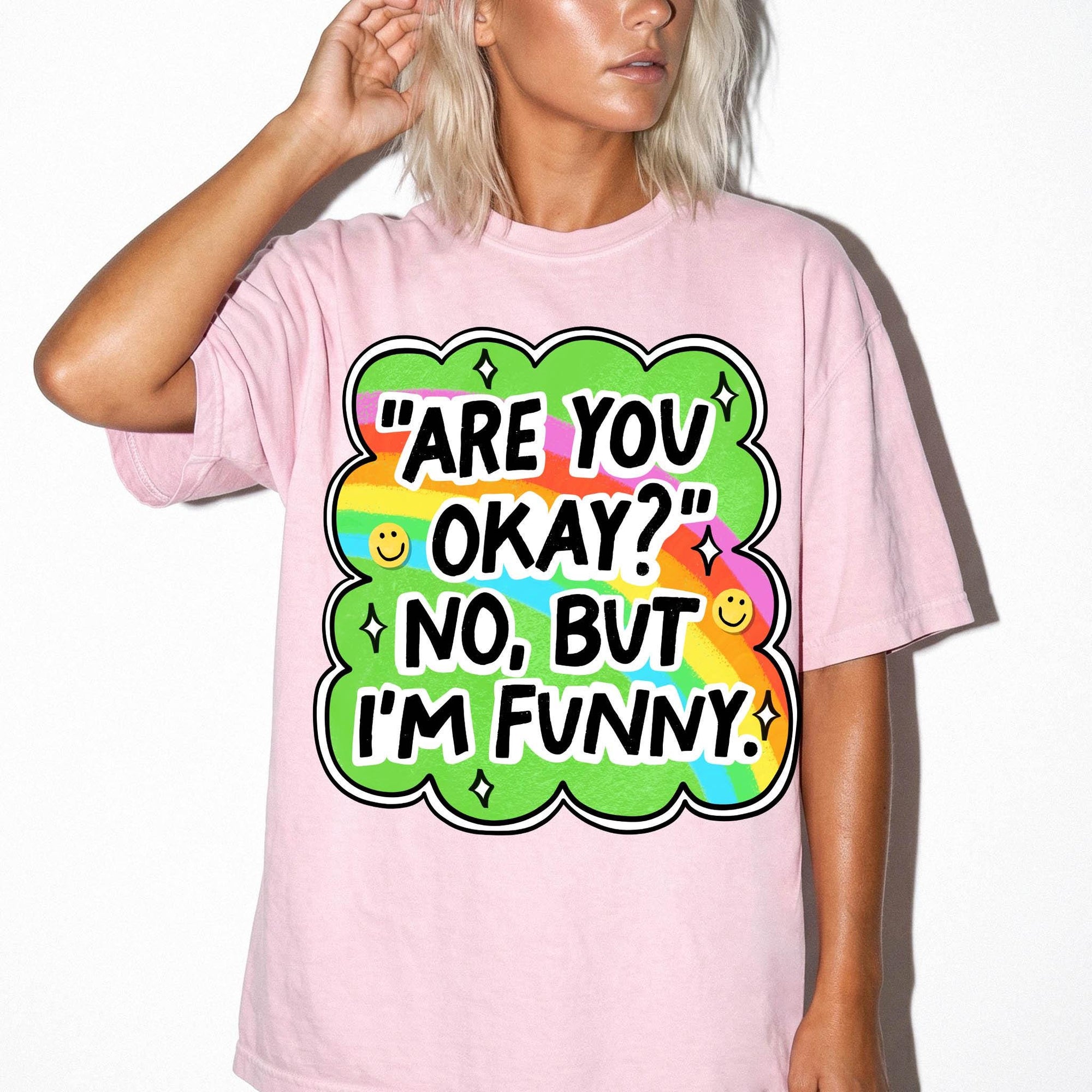 A woman wearing a pink t-shirt with a colorful graphic and text on it.