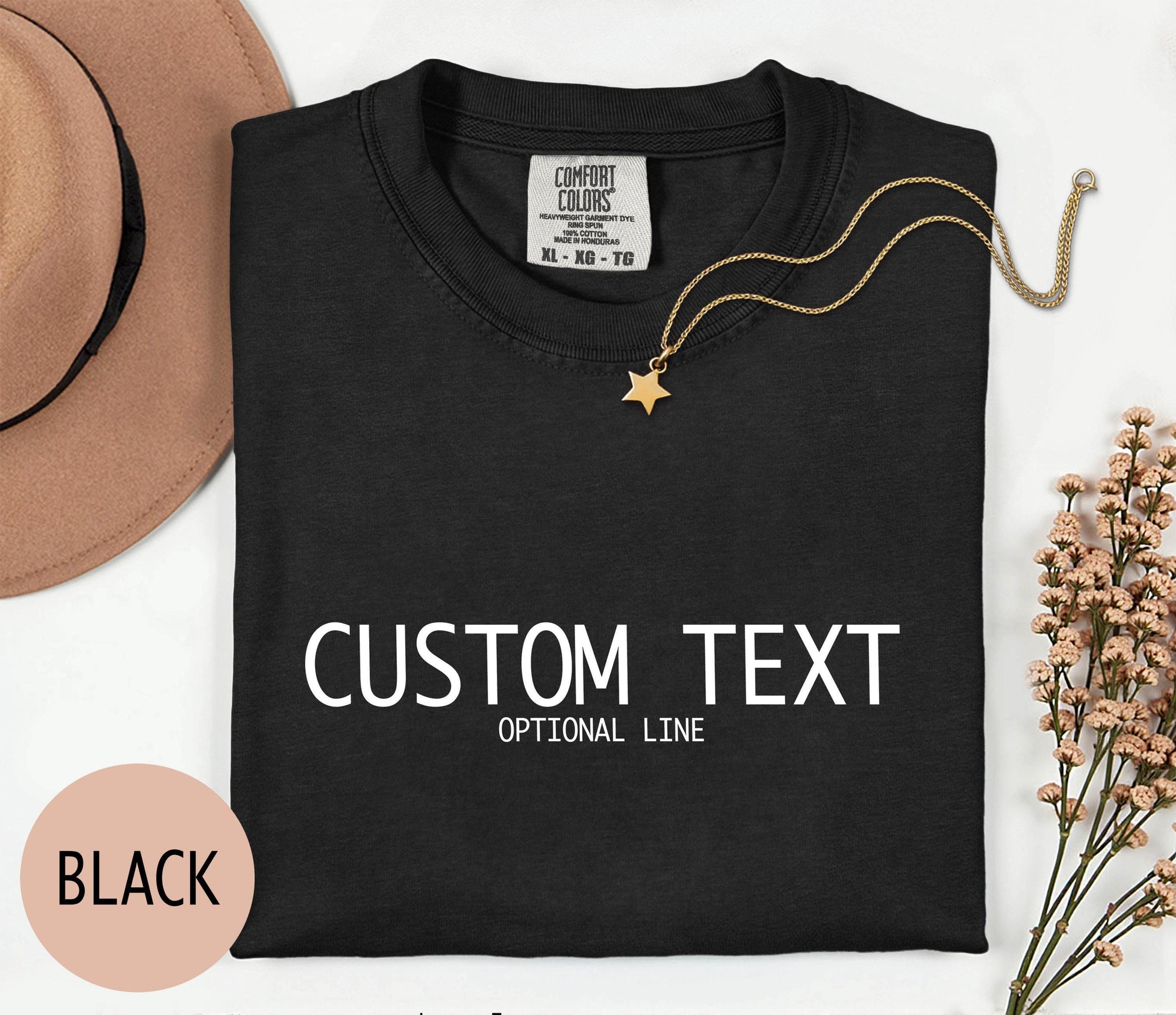 a black t-shirt with white text, a gold star pendant, and a brown hat, along with some flowers and a pink circle.