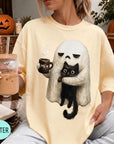 A woman wearing a yellow t-shirt with a graphic of a ghost holding a coffee mug and a black cat.